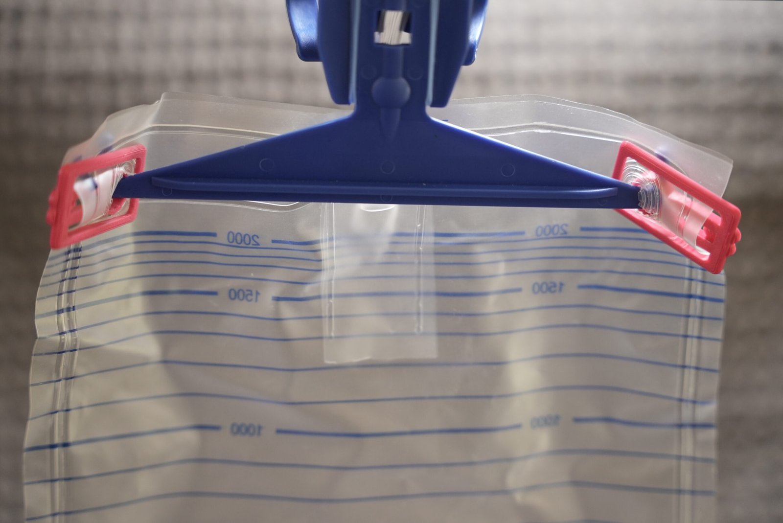 Assure 2000 ml urine bag showing the upper hanging holes for Uroclips compatibility checking